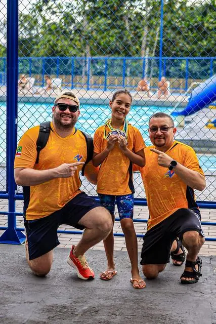 Lelê com a equipe técnica, todos de laranja